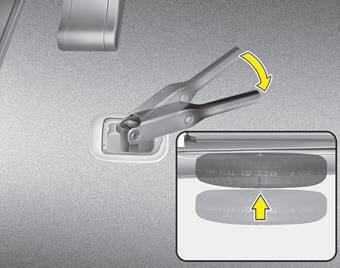 Kia Carnival: Storing the spare tire Kia Carnival: Storing the spare tire. 2. Place the wheel under the vehicle and install the retainer through the wheel